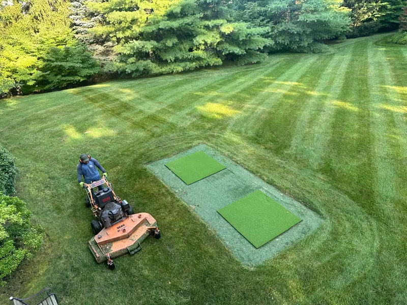 Baudi crew mowing a striped lawn on a Westchester property
