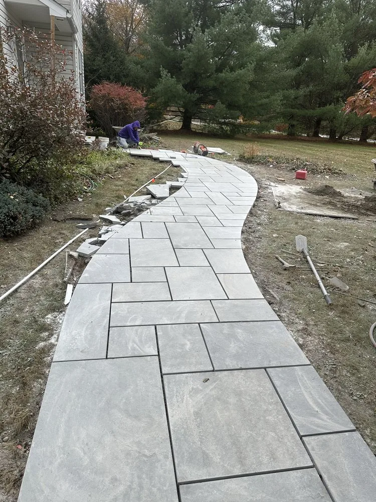 Long curving bluestone walkway freshly set between lawn and planting beds at a Westchester home
